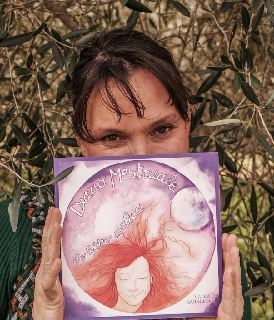 Immagine di Nadia Saracco con il diario "Il Diario della Mia Fata del Grembo": Nadia Saracco tiene in mano il diario mestruale "Io sono Ciclica"