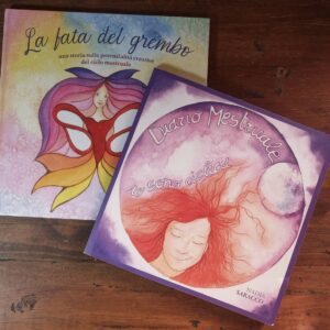 Immagine del pacchetto che include il libro "La Fata del Grembo" e il diario mestruale "Io Sono Ciclica". Il libro è riccamente illustrato e il diario presenta design evocativo, entrambi progettati per celebrare la ciclicità e il potere creativo femminile.